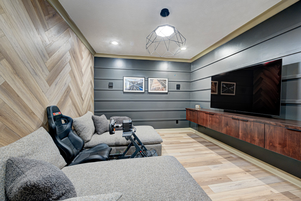 Design ideas for a medium sized contemporary enclosed games room in Indianapolis with multi-coloured walls, a wall mounted tv, light hardwood flooring, brown floors and panelled walls.