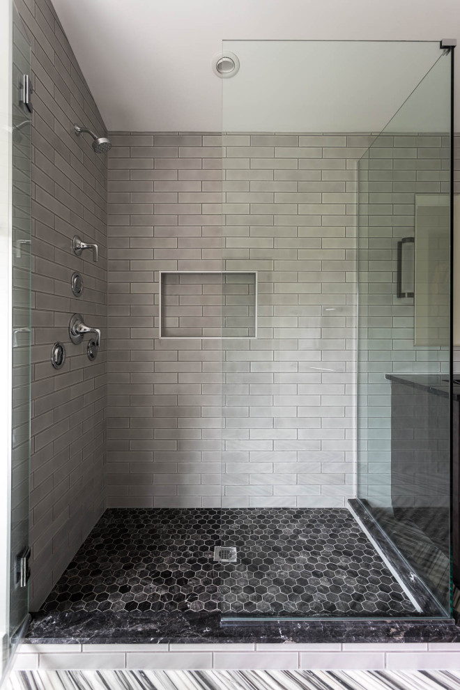 This is an example of a large transitional master bathroom in Denver with flat-panel cabinets, dark wood cabinets, a freestanding tub, a corner shower, a two-piece toilet, gray tile, porcelain tile, white walls, marble floors, an undermount sink, marble benchtops, multi-coloured floor, a hinged shower door, grey benchtops, an enclosed toilet, a double vanity, a freestanding vanity and vaulted.