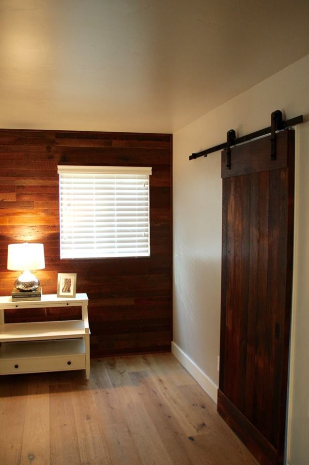This is an example of a country master bedroom in San Luis Obispo with grey walls and light hardwood floors.