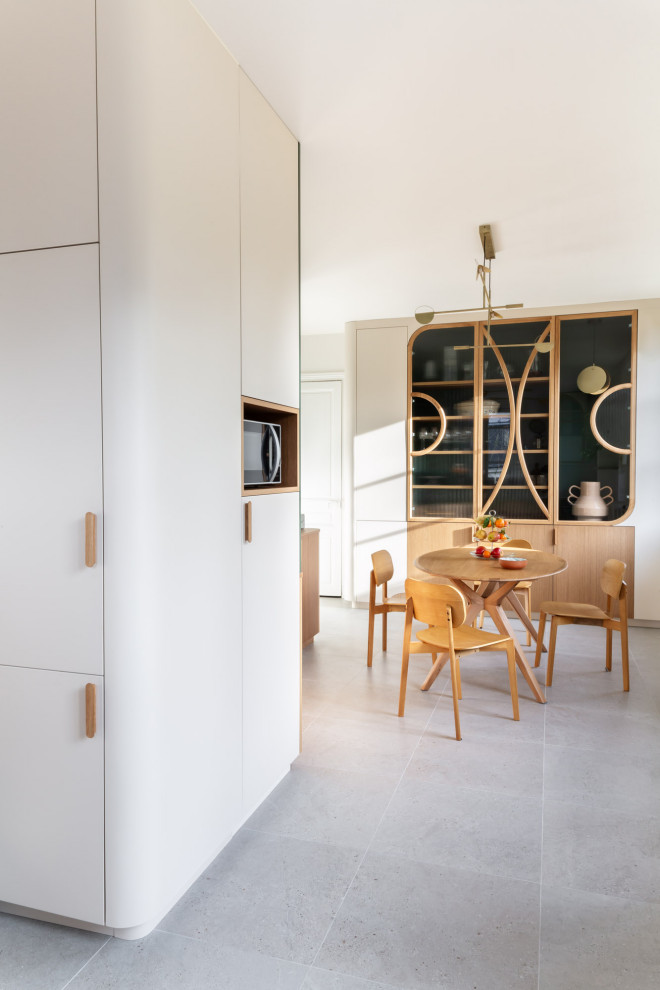 Foto di una grande sala da pranzo aperta verso la cucina design con pareti bianche, pavimento con piastrelle in ceramica e pavimento grigio