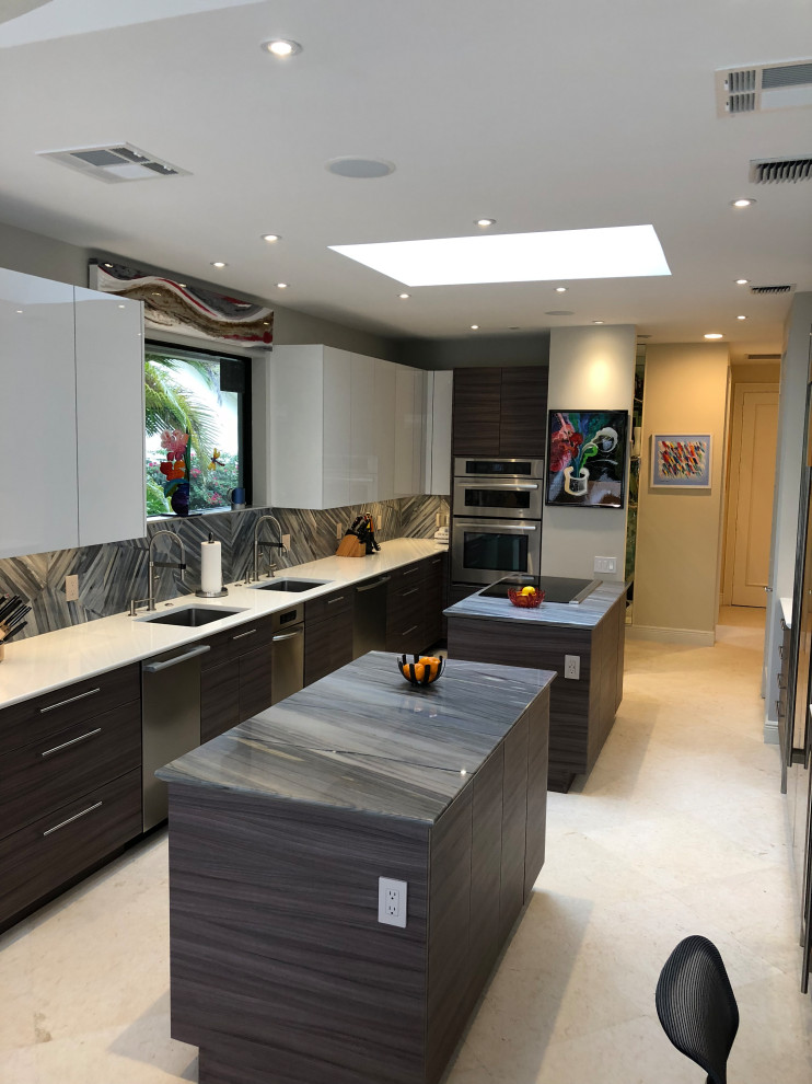 Design ideas for a large modern galley separate kitchen in Miami with an undermount sink, flat-panel cabinets, porcelain splashback, stainless steel appliances, limestone floors, multiple islands and beige floor.
