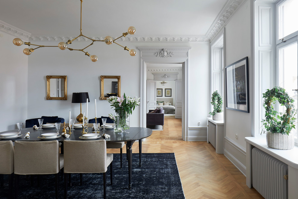 Design ideas for a scandinavian separate dining room in Stockholm with white walls, light hardwood floors and beige floor.