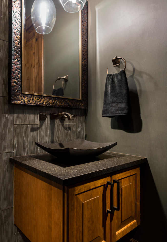 Design ideas for a mid-sized transitional powder room in Portland with raised-panel cabinets, medium wood cabinets, gray tile, glass tile, grey walls, a vessel sink and granite benchtops.