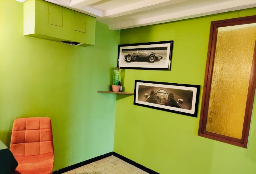 This is an example of a mid-sized midcentury study room in Dijon with green walls, ceramic floors, no fireplace, a freestanding desk, brown floor and exposed beam.