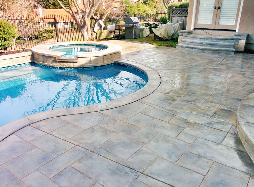 Large arts and crafts backyard custom-shaped natural pool in San Francisco with stamped concrete.