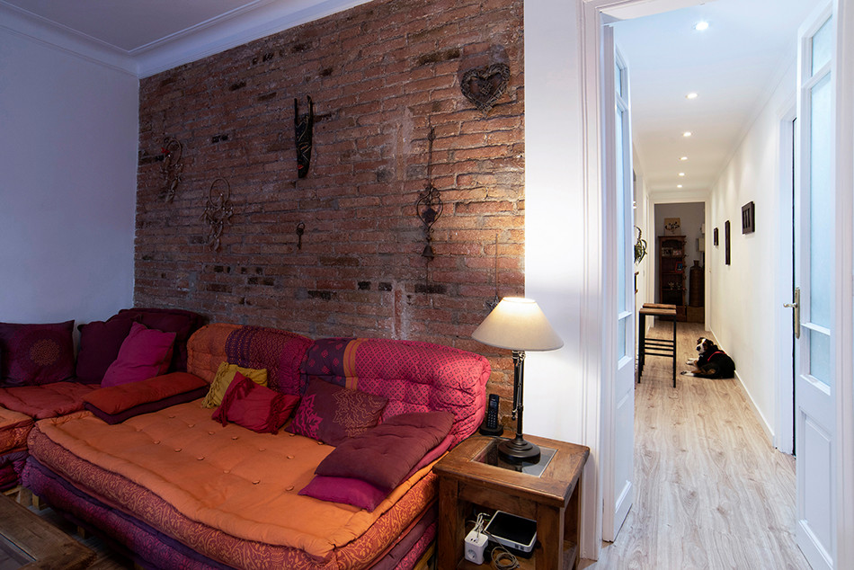Mittelgroßes, Abgetrenntes Rustikales Wohnzimmer mit brauner Wandfarbe, Laminat, beigem Boden und Ziegelwänden in Barcelona