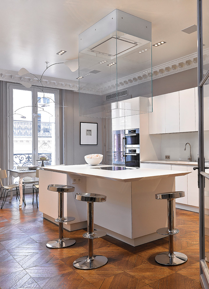 Large contemporary galley eat-in kitchen in Paris with with island, white cabinets and white splashback.