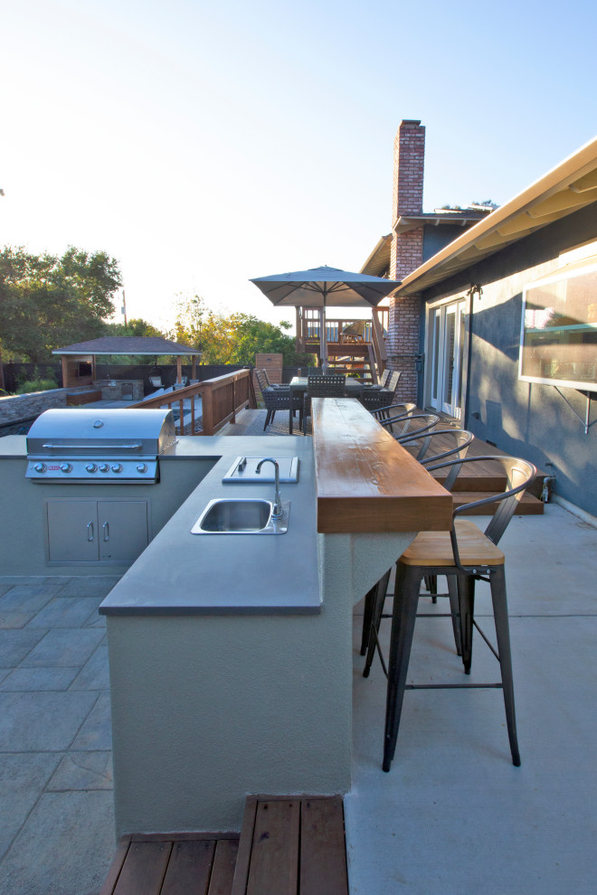 Large modern backyard patio in San Luis Obispo with an outdoor kitchen, concrete pavers and a gazebo/cabana.