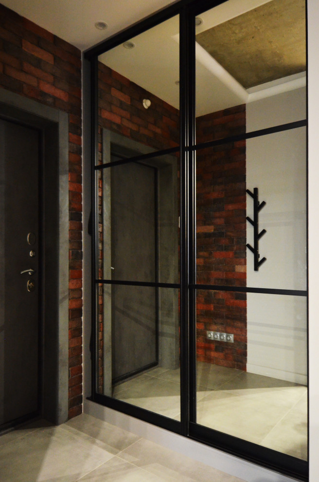 Источник вдохновения для домашнего уюта: маленькая входная дверь в современном стиле с коричневыми стенами, полом из керамогранита, одностворчатой входной дверью, серой входной дверью, серым полом и кирпичными стенами для на участке и в саду