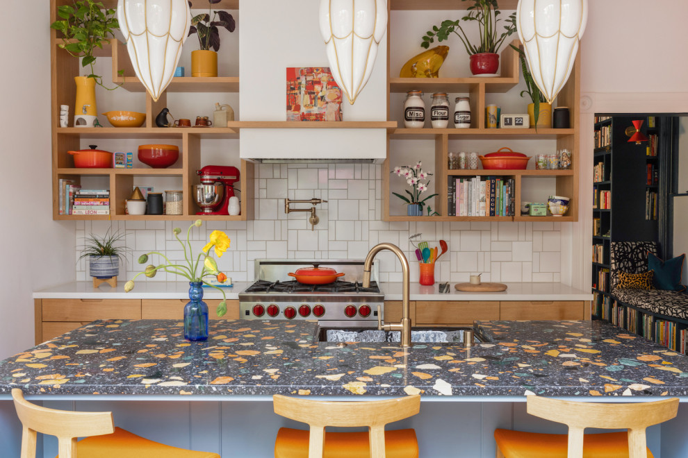 サンフランシスコにあるエクレクティックスタイルのおしゃれなアイランドキッチン (エプロンフロントシンク、フラットパネル扉のキャビネット、白いキッチンパネル、セラミックタイルのキッチンパネル、マルチカラーのキッチンカウンター) の写真