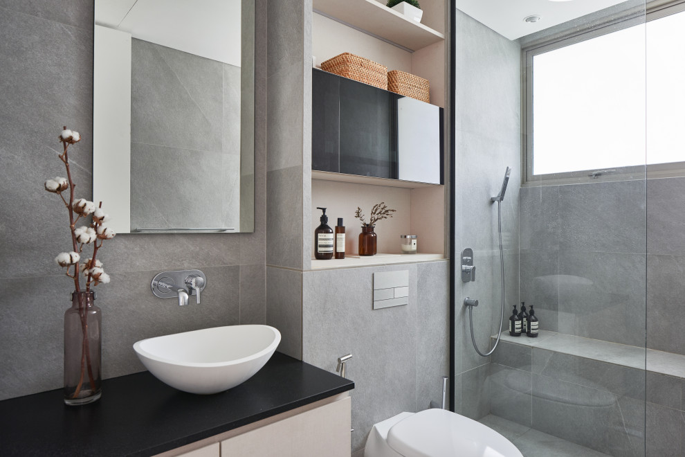 Exemple d'une douche en alcôve tendance avec un placard à porte plane, des portes de placard blanches, WC suspendus, un carrelage gris, une vasque, un sol gris, un plan de toilette noir, un banc de douche, meuble simple vasque et meuble-lavabo suspendu.