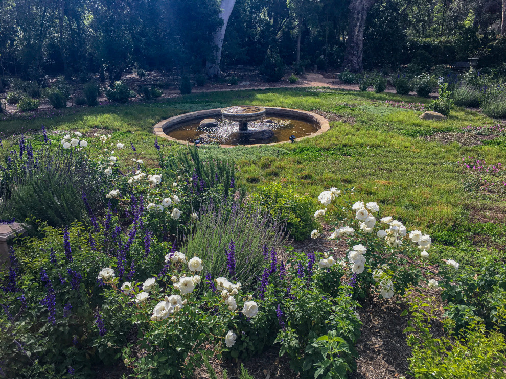 Esempio di un ampio giardino country con fontane e ghiaia