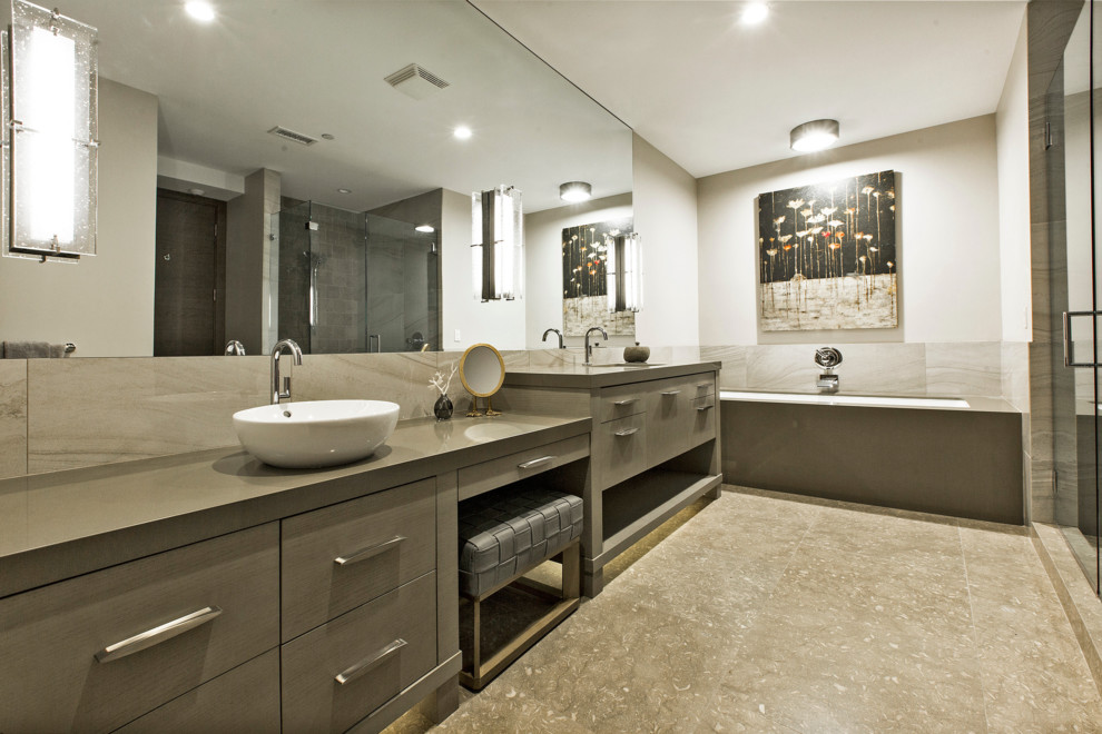 This is an example of a mid-sized contemporary master bathroom in Salt Lake City with flat-panel cabinets, grey cabinets, a drop-in tub, an alcove shower, beige tile, porcelain tile, beige walls, limestone floors, a vessel sink, engineered quartz benchtops, beige floor and a hinged shower door.