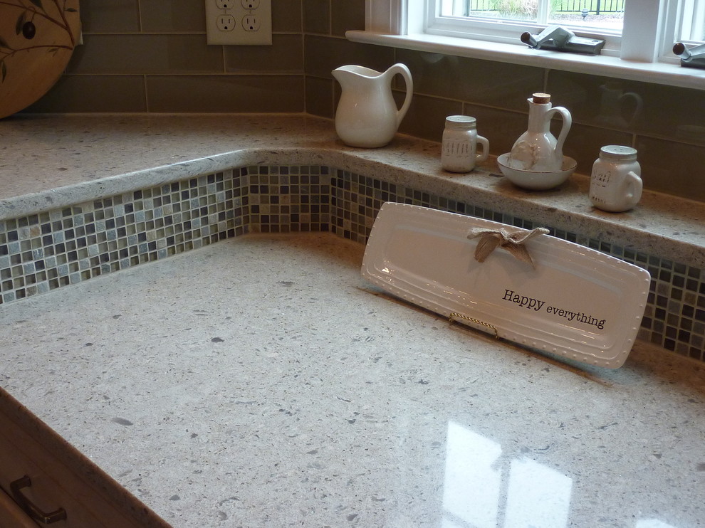 Bathroom - large transitional l-shaped ceramic tile bathroom idea with an undermount sink, raised-panel cabinets, light wood cabinets, quartzite countertops, beige backsplash, glass tile backsplash, stainless steel appliances and an island