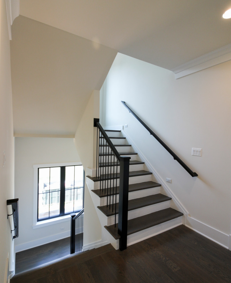Photo of a mid-sized contemporary wood u-shaped staircase in DC Metro with wood risers and metal railing.