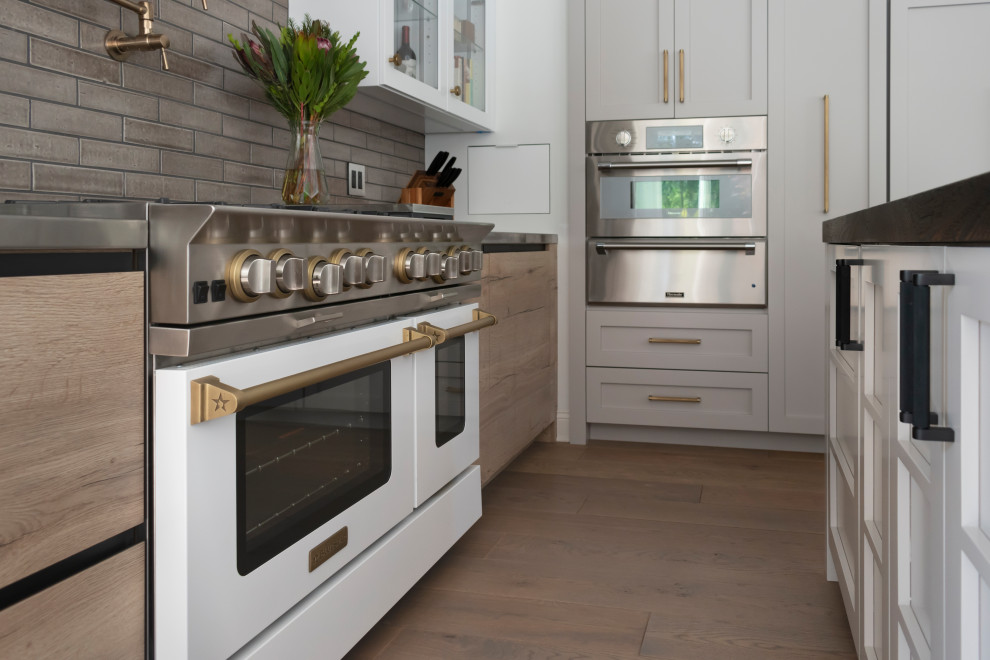 Exempel på ett mellanstort rustikt kök, med en undermonterad diskho, luckor med glaspanel, vita skåp, bänkskiva i rostfritt stål, brunt stänkskydd, stänkskydd i keramik, färgglada vitvaror, ljust trägolv, flera köksöar och beiget golv