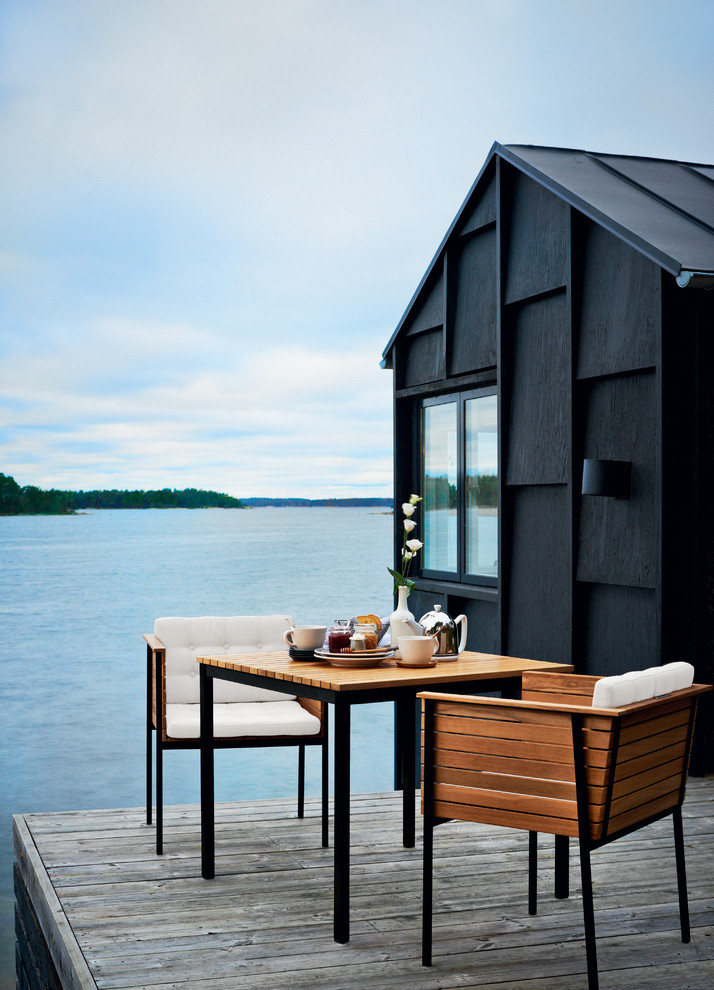 Small scandinavian one-storey black exterior in Stockholm with wood siding.