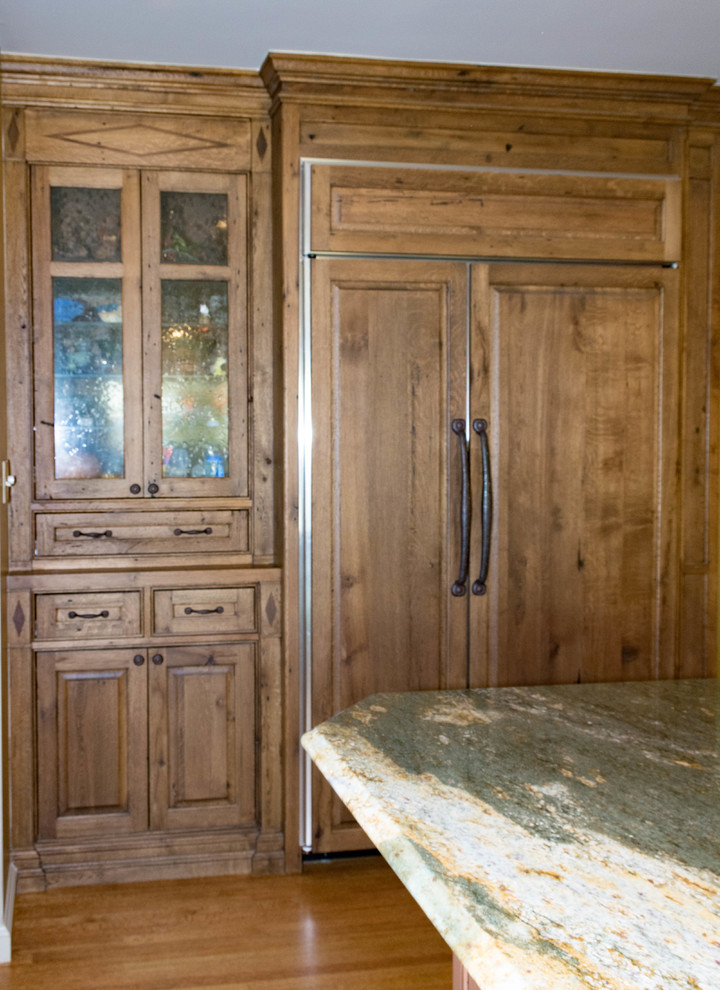 Example of a large mountain style u-shaped eat-in kitchen design with distressed cabinets, granite countertops, stone slab backsplash, stainless steel appliances and an island