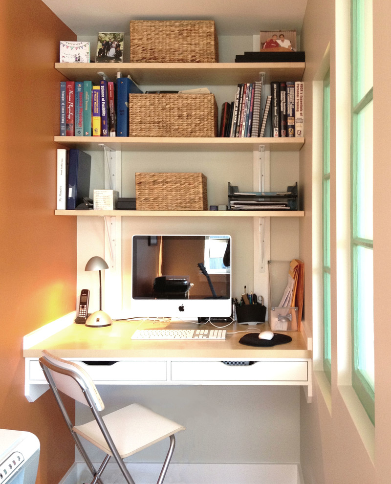 Photo of a small contemporary home office in Vancouver with orange walls and a built-in desk.