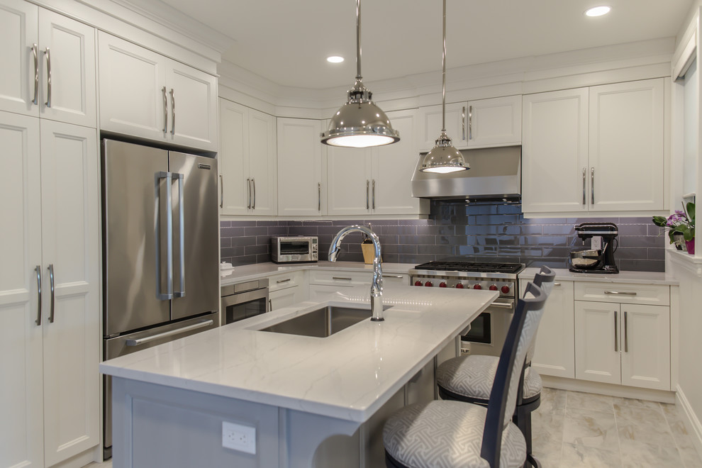 Mid-sized modern l-shaped eat-in kitchen in Toronto with an undermount sink, shaker cabinets, white cabinets, grey splashback, glass tile splashback, stainless steel appliances and with island.