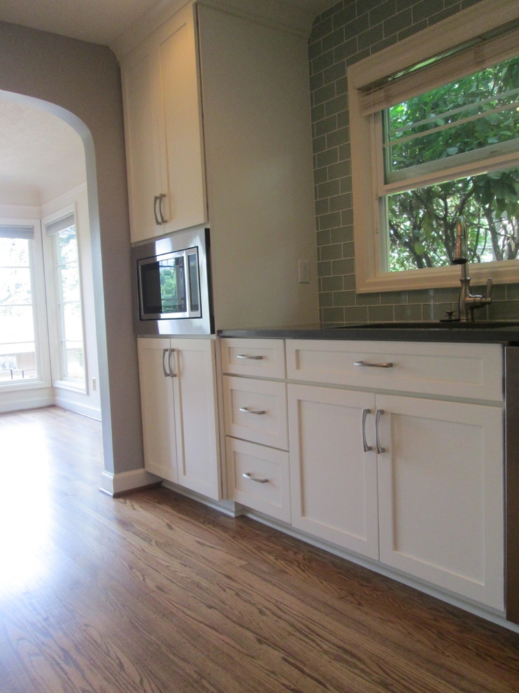 Photo of a mid-sized transitional u-shaped separate kitchen in Portland with an undermount sink, shaker cabinets, white cabinets, quartzite benchtops, green splashback, glass tile splashback, stainless steel appliances, medium hardwood floors and no island.