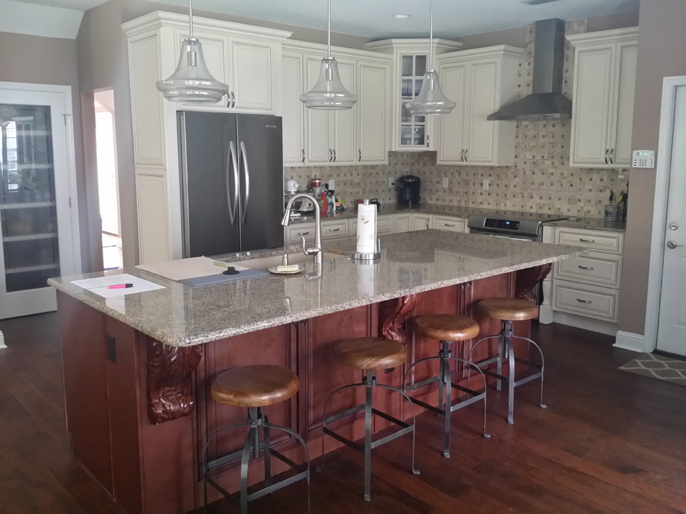 Mid-sized transitional l-shaped dark wood floor and brown floor eat-in kitchen photo in Orange County with an undermount sink, raised-panel cabinets, white cabinets, granite countertops, gray backsplash, ceramic backsplash, stainless steel appliances and an island