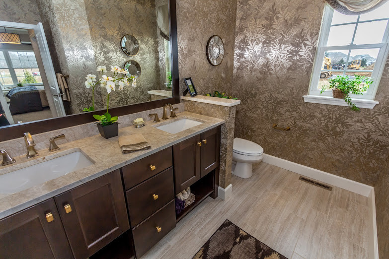 Inspiration for a transitional master ceramic tile and beige floor bathroom remodel with shaker cabinets, dark wood cabinets, a one-piece toilet, beige walls, an undermount sink and quartzite countertops