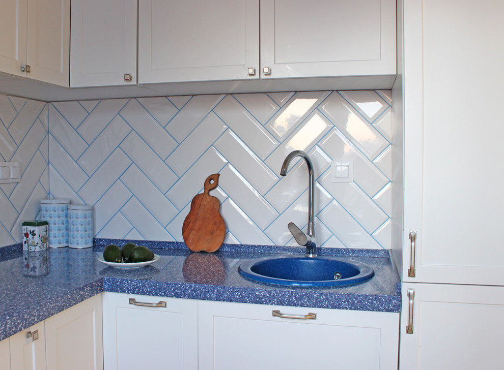 Inspiration for a small scandinavian u-shaped eat-in kitchen in Moscow with an undermount sink, raised-panel cabinets, white cabinets, solid surface benchtops, white splashback, subway tile splashback, white appliances, porcelain floors, no island, white floor and blue benchtop.