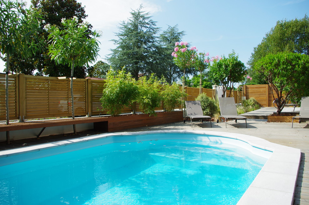 Photo of a small beach style front yard pool in Bordeaux with decking.