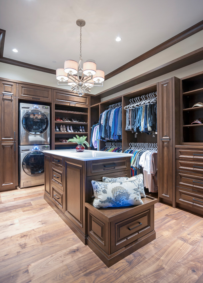 Mid-sized country gender-neutral dressing room in Calgary with raised-panel cabinets, medium wood cabinets, medium hardwood floors and brown floor.