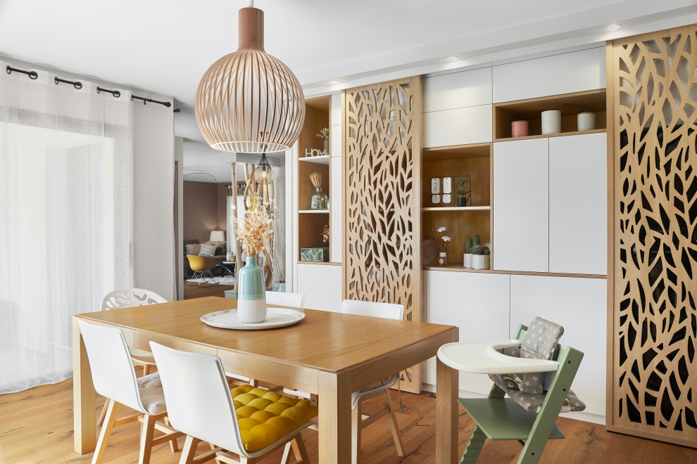 This is an example of a mid-sized scandinavian dining room in Nantes with beige walls, light hardwood floors and beige floor.