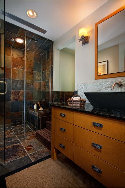 Mid-sized transitional 3/4 bathroom in Orange County with a vessel sink, furniture-like cabinets, medium wood cabinets, onyx benchtops, a curbless shower, a one-piece toilet, multi-coloured tile, stone tile, green walls and slate floors.