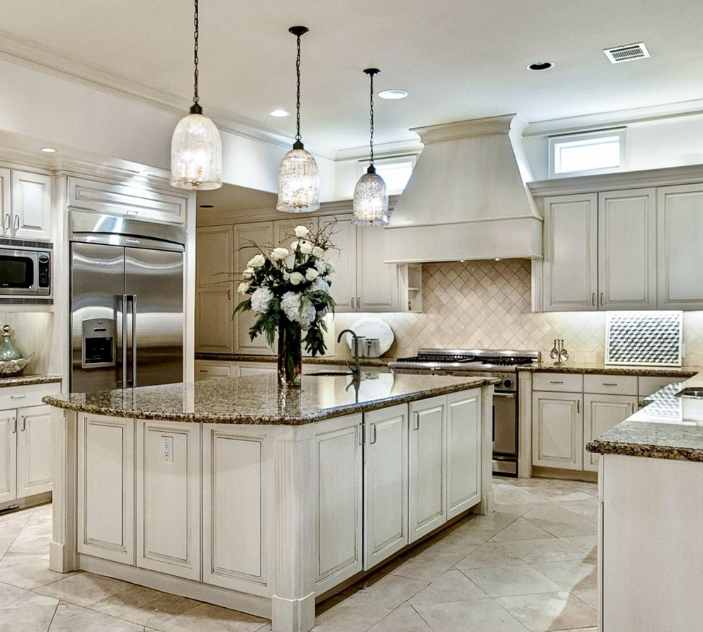 Example of a large transitional u-shaped travertine floor eat-in kitchen design in Houston with an undermount sink, raised-panel cabinets, light wood cabinets, granite countertops, beige backsplash, stone tile backsplash, stainless steel appliances and an island