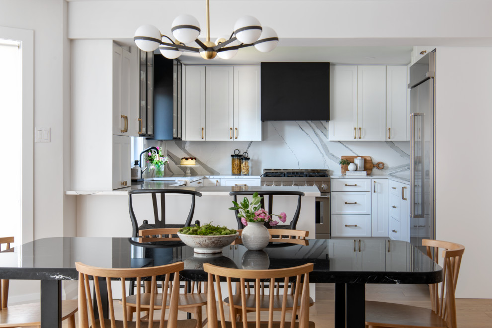 Eat-in kitchen - mid-sized transitional u-shaped light wood floor and brown floor eat-in kitchen idea in Ottawa with an undermount sink, shaker cabinets, white cabinets, quartz countertops, white backsplash, quartz backsplash, stainless steel appliances, a peninsula and white countertops