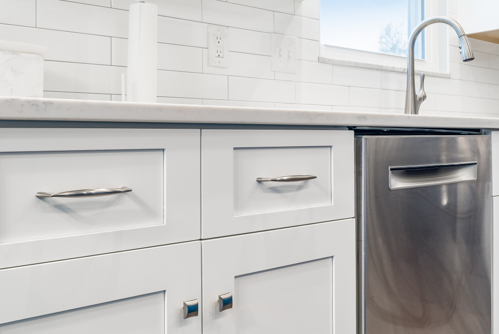 Example of a mid-sized transitional l-shaped eat-in kitchen design in Columbus with shaker cabinets, quartz countertops, white backsplash, subway tile backsplash and an island