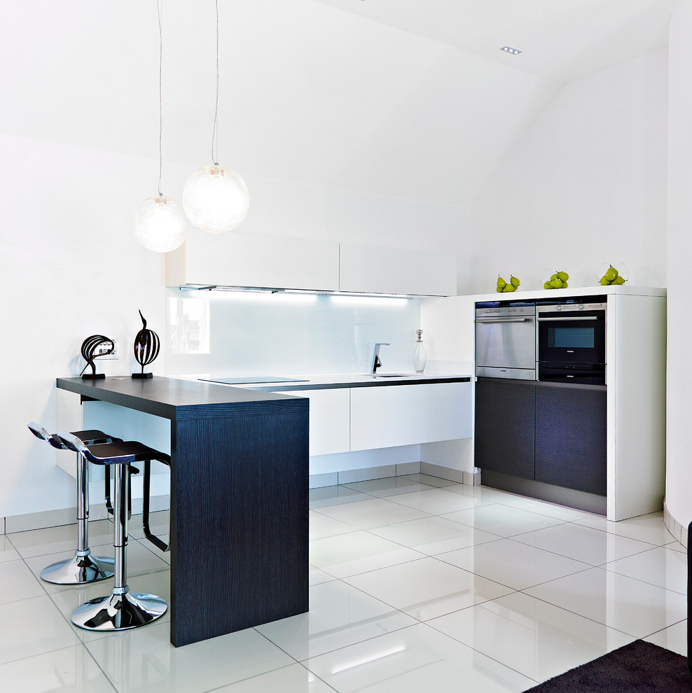 Inspiration for a contemporary l-shaped kitchen in Other with an undermount sink, flat-panel cabinets, white cabinets, white splashback, glass sheet splashback and stainless steel appliances.