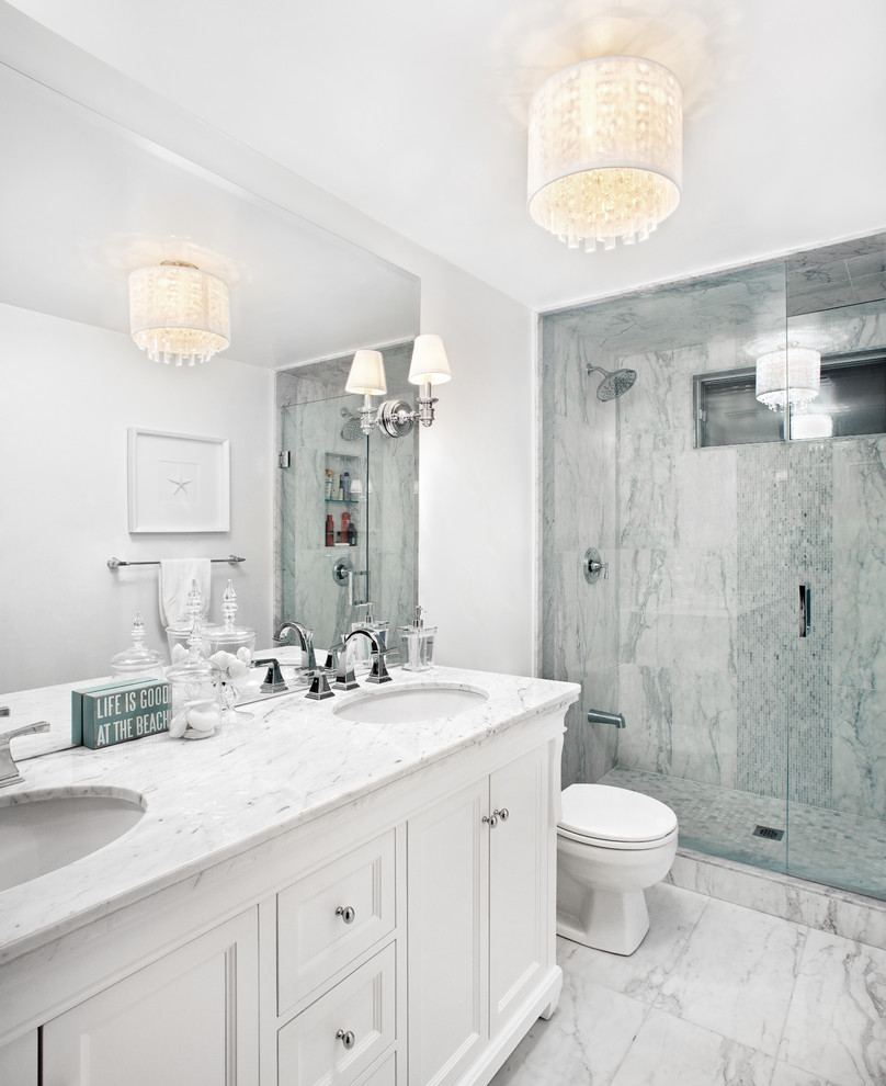 This is an example of a mid-sized traditional master bathroom in Toronto with an undermount sink, white cabinets, marble benchtops, white tile, stone tile, white walls, marble floors, an alcove shower and recessed-panel cabinets.