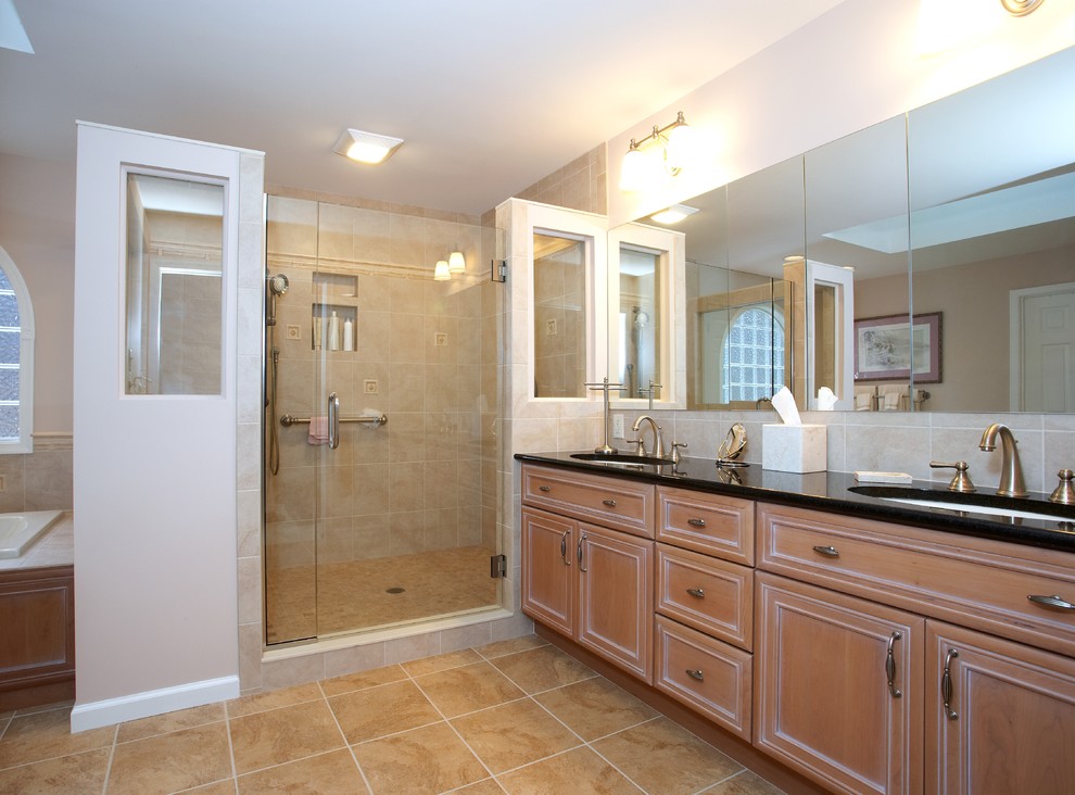 This is an example of a large traditional master bathroom in Other with granite benchtops, an undermount sink, beaded inset cabinets, light wood cabinets, a drop-in tub, a corner shower, beige tile, limestone, beige walls, ceramic floors, beige floor and a hinged shower door.
