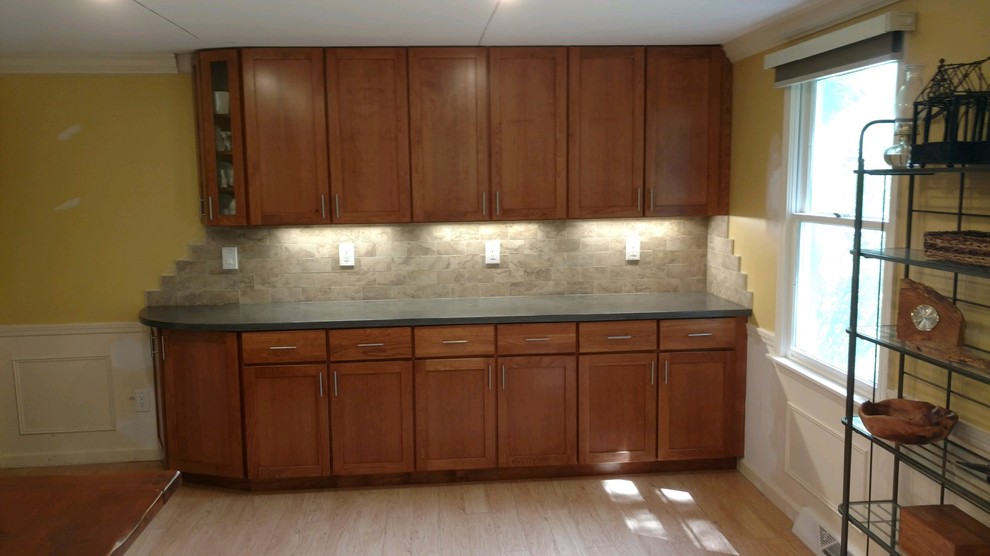 Minimalist kitchen photo in New York with an undermount sink, shaker cabinets, solid surface countertops, beige backsplash, ceramic backsplash, stainless steel appliances, an island and gray countertops