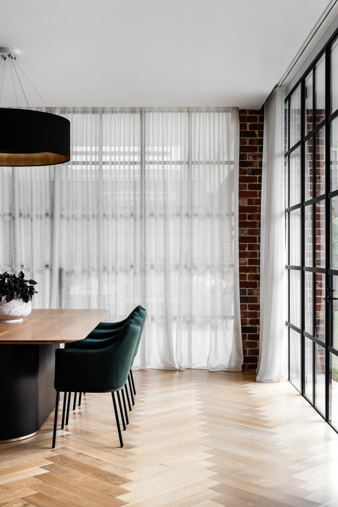 Große Moderne Wohnküche mit braunem Holzboden und Ziegelwänden in Melbourne