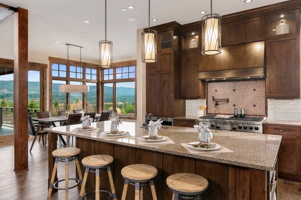 Inspiration for a country eat-in kitchen in Seattle with with island, dark wood cabinets, stainless steel appliances, brown floor, an undermount sink, shaker cabinets, multi-coloured splashback and medium hardwood floors.