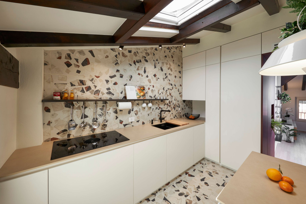 Foto på ett funkis beige l-kök, med en undermonterad diskho, släta luckor, vita skåp, flerfärgad stänkskydd, terrazzogolv, en köksö och flerfärgat golv