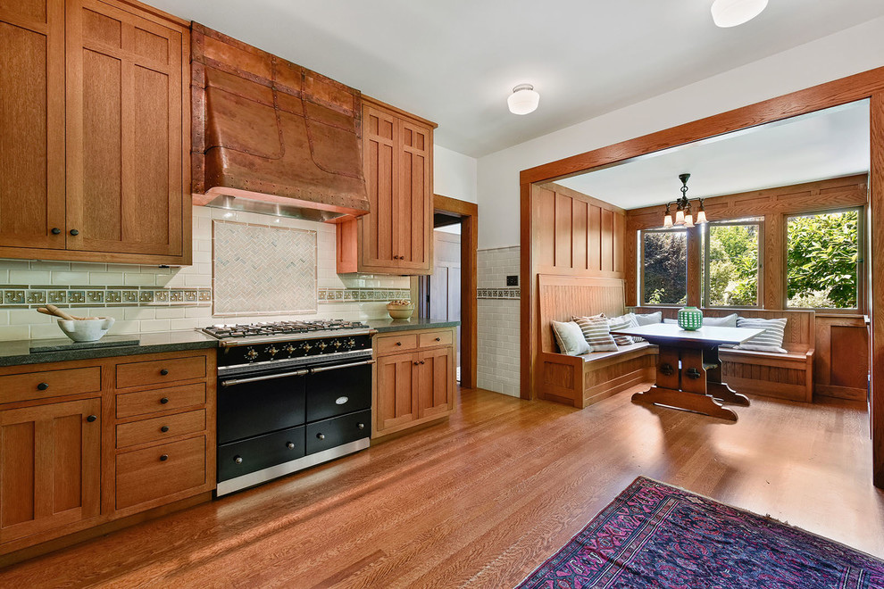 Inspiration for an arts and crafts l-shaped eat-in kitchen in San Francisco with recessed-panel cabinets, ceramic splashback, stainless steel appliances, medium hardwood floors, beige floor and green benchtop.