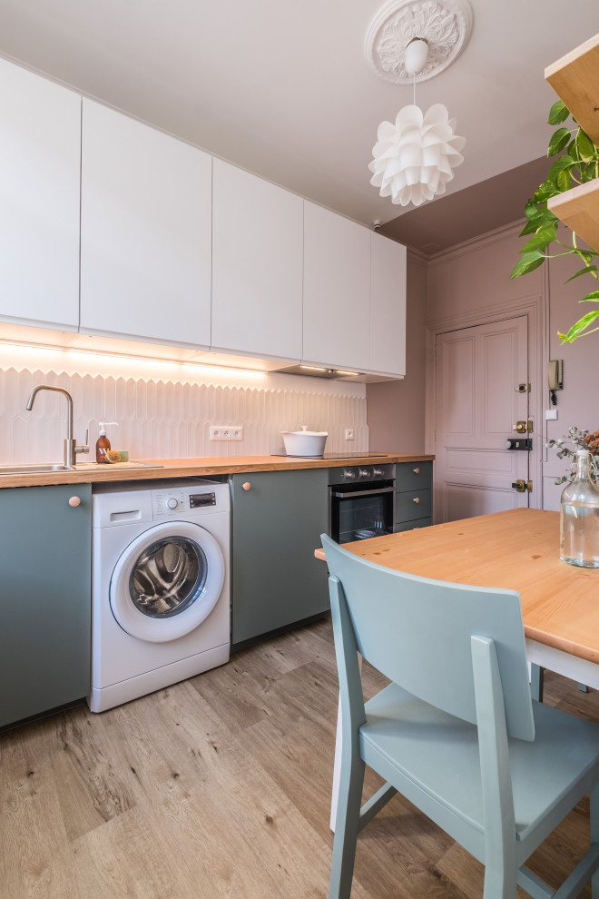 Photo of a small contemporary single-wall enclosed kitchen in Toulouse with a submerged sink, flat-panel cabinets, white cabinets, wood worktops, white splashback, ceramic splashback, stainless steel appliances, laminate floors, no island and beige floors.
