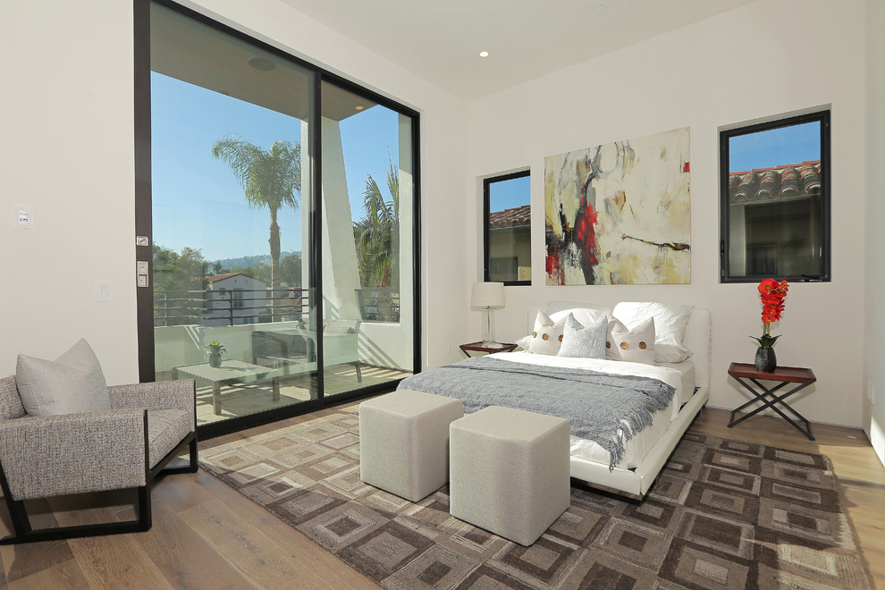This is an example of a contemporary bedroom in Los Angeles with white walls and medium hardwood floors.