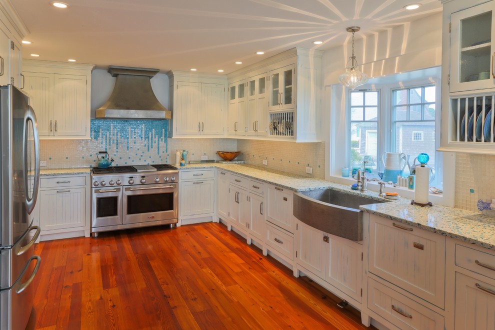 Photo of a beach style kitchen in Boston with an undermount sink, distressed cabinets, blue splashback, shaker cabinets, recycled glass benchtops and glass tile splashback.