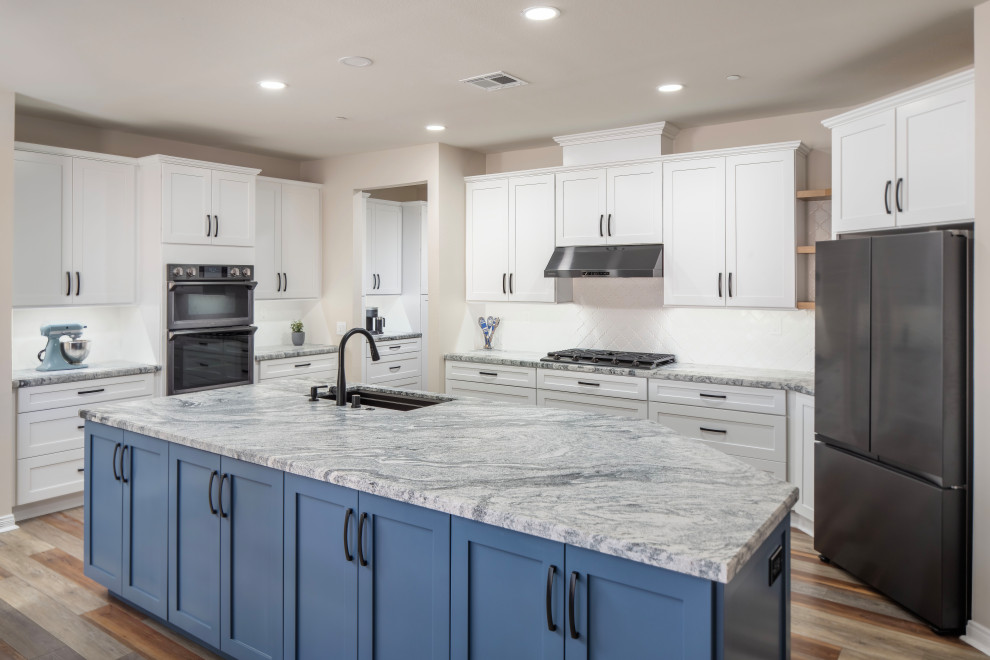 Klassisk inredning av ett stort grå grått kök, med en enkel diskho, skåp i shakerstil, blå skåp, granitbänkskiva, vitt stänkskydd, stänkskydd i keramik, svarta vitvaror, laminatgolv, en köksö och blått golv