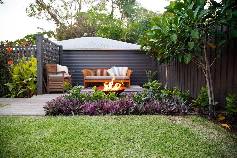 Inspiration for a tropical patio in Brisbane with a fire feature.