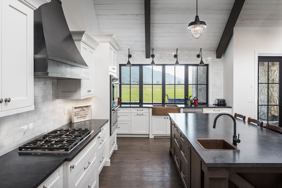 Inspiration for an expansive country u-shaped open plan kitchen in Vancouver with a farmhouse sink, shaker cabinets, white cabinets, laminate benchtops, white splashback, marble splashback, stainless steel appliances, dark hardwood floors, with island and brown floor.