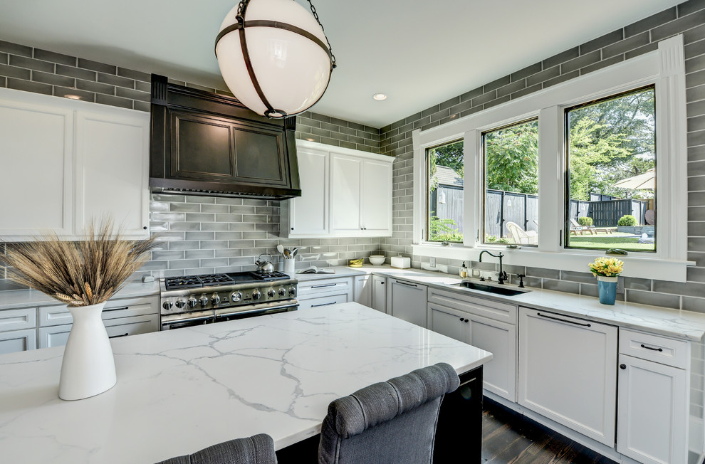 Photo of a large traditional u-shaped eat-in kitchen in Atlanta with an undermount sink, flat-panel cabinets, white cabinets, quartz benchtops, grey splashback, ceramic splashback, stainless steel appliances, dark hardwood floors and with island.